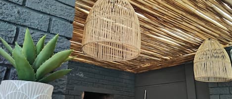 A modern interior with a brick wall, a black ceiling, and a fireplace.