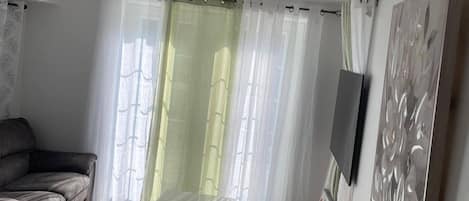 Ein modernes Wohnzimmer mit einem Marmortisch, einem grauen Sofa und einem an der Wand befestigten Fernseher.