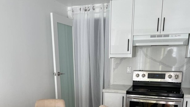 Eine moderne Küche mit Backofen und einem Esstisch aus Marmor mit Stühlen.