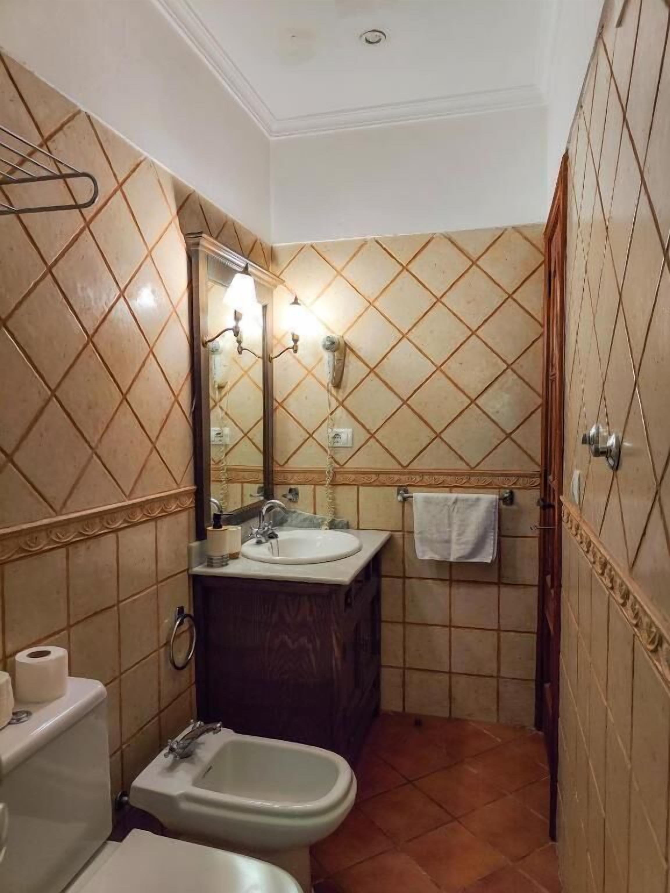 Ein Badezimmer mit Toilette, Bidet, Waschbecken und Spiegel.
