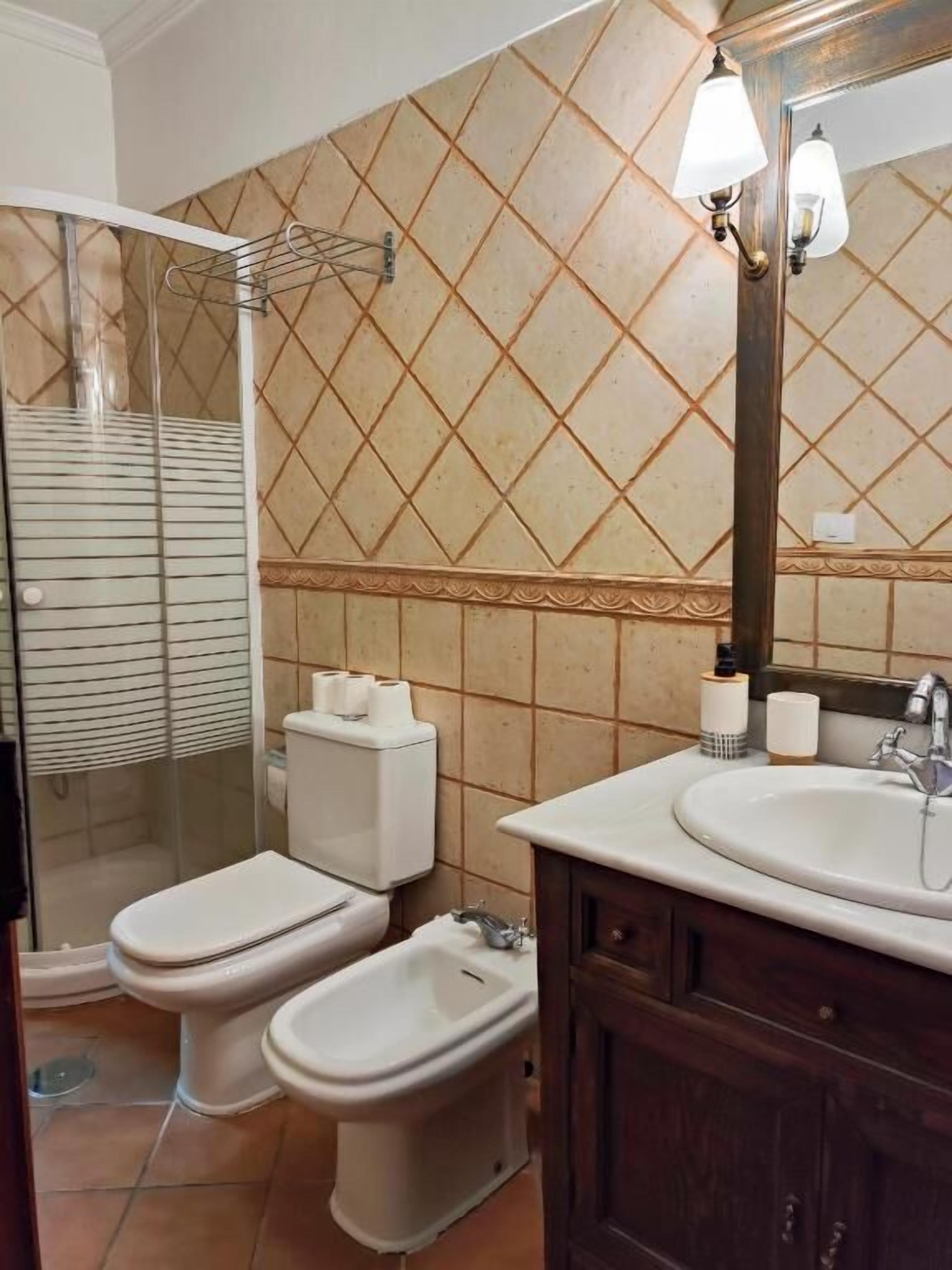 Ein Badezimmer mit Dusche, Toilette, Bidet und Waschbecken.