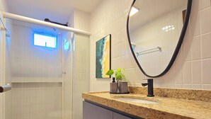 A modern bathroom with a shower, toilet, and a large mirror. - Jardins do Atlântico By Hosppedar (João Pessoa)
