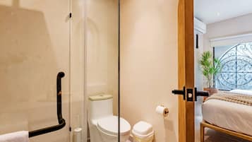 Un bagno moderno con box doccia in vetro, un water e un bidet.