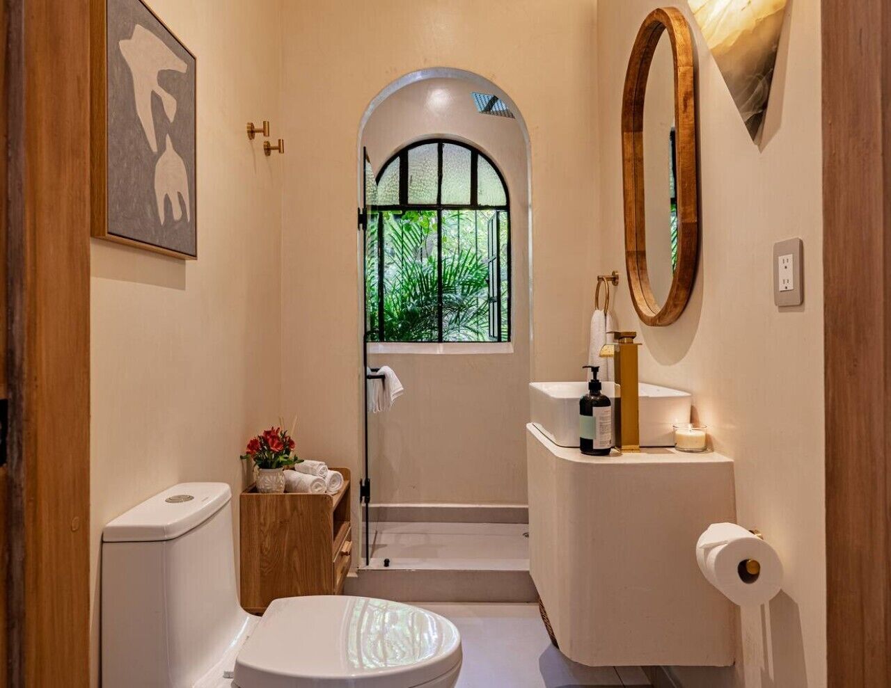 Baño con inodoro, lavabo y zona de ducha.
