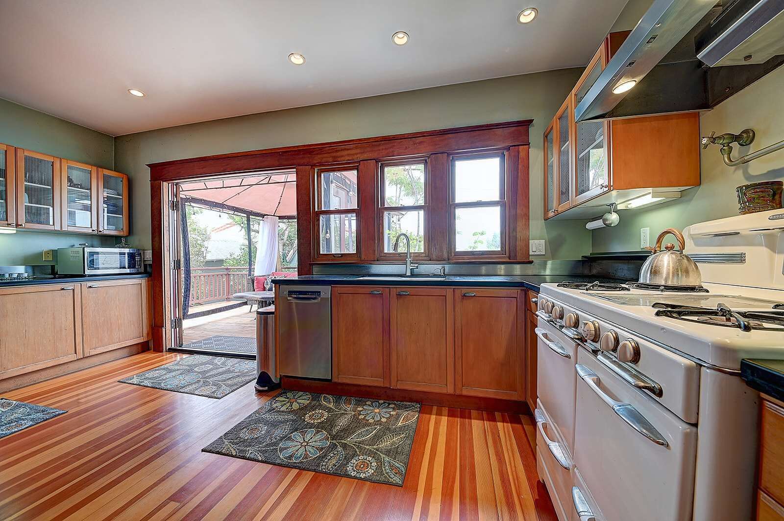 A kitchen with wooden cabinets, a stove, and a microwave.