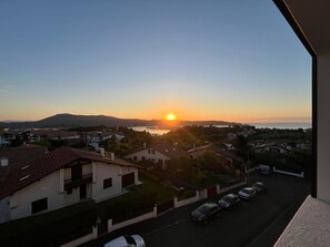 A residential area with houses, a street, and a sunset view. - Quiet apartment with a view of Hendaye Bay (Hendaye)