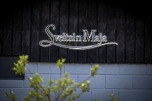 Un letrero con el texto 'Sweetsin MaJa' sobre un fondo de madera oscura.