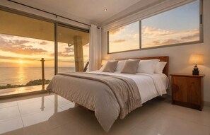 A bedroom with a large bed, a nightstand, and a view of the sunset over the ocean. - Overhang Villa – Oceanview & Infinity Pool | Uvita (Bahía Ballena)