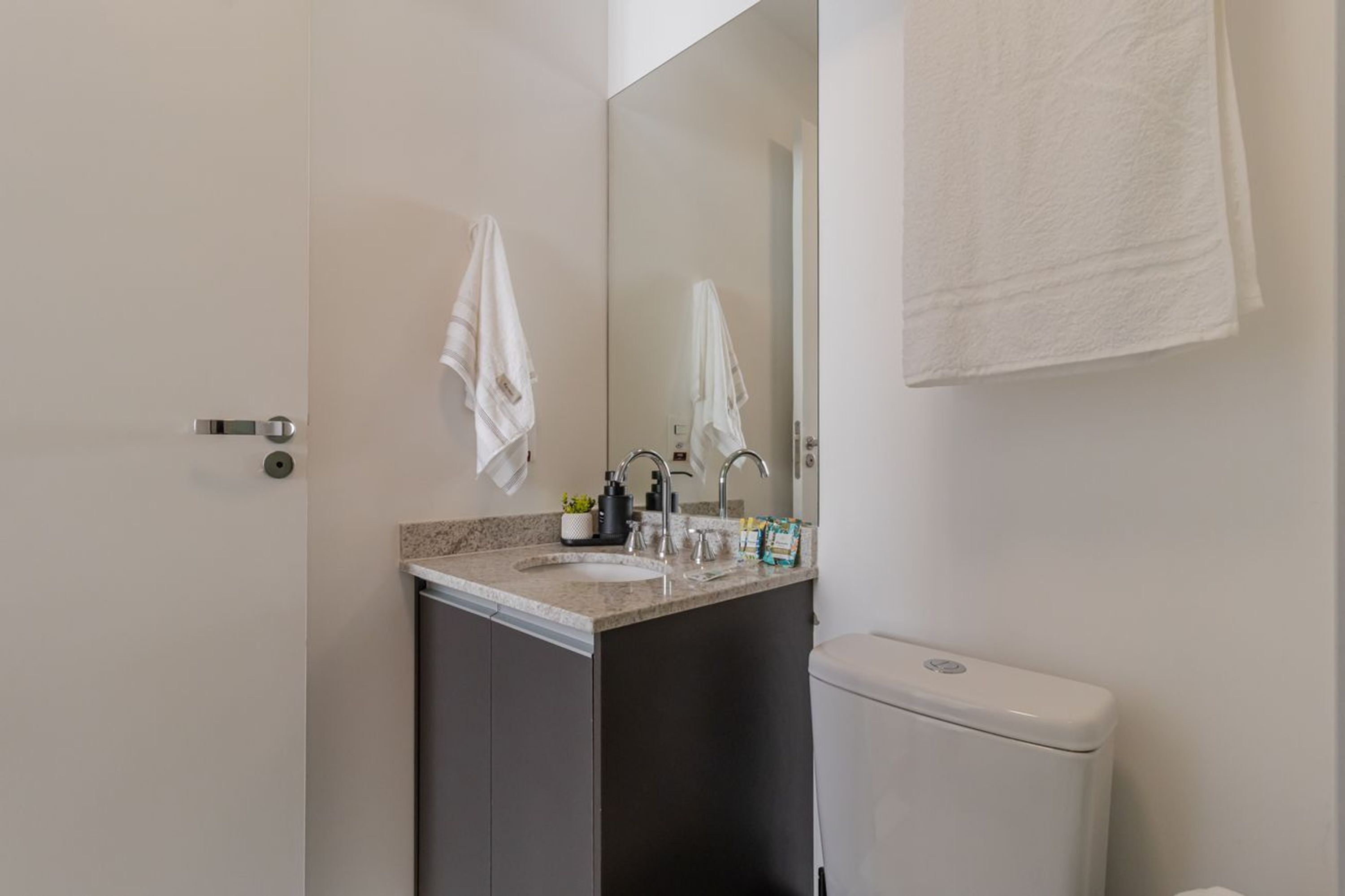 Une salle de bain avec des toilettes, un lavabo et un miroir.