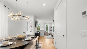 A modern dining area with a round table, chairs, and a chandelier. - Velvet Note@ The New Cumberland Side B (Nashville)