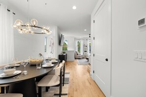 A modern dining area with a round table, chairs, and a chandelier. - Velvet Note@ The New Cumberland Side B (Nashville)