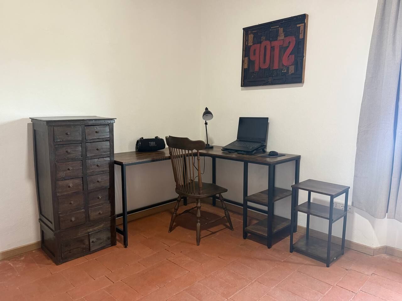 Ein Arbeitsplatz mit Schreibtisch, Stuhl, Laptop und Stauraum.
