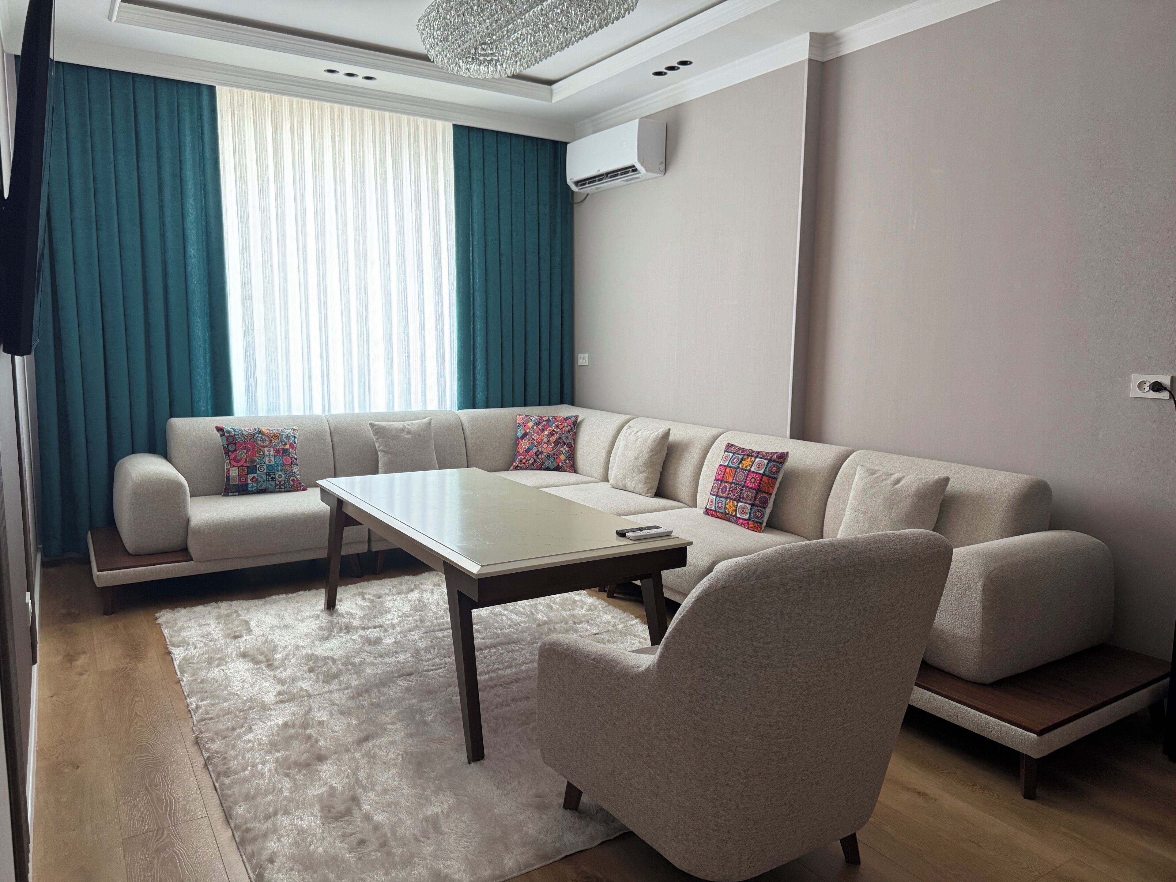 Ein modernes Wohnzimmer mit einem Ecksofa, einem Couchtisch und einem Kissen mit Muster.