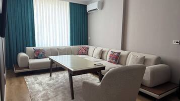 Ein modernes Wohnzimmer mit einem Ecksofa, einem Couchtisch und einem Kissen mit Muster.