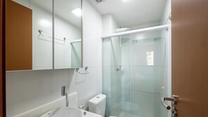 A modern bathroom with a glass shower enclosure, a white sink, and a toilet. - Apt. in Condo. w/ Pool in Barra Znb0605 (Salvador)