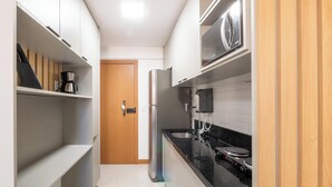 A modern kitchen with white cabinets, a black countertop, and a stainless steel refrigerator. - Apt. in Condo. w/ Pool in Barra Znb0605 (Salvador)