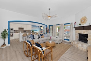 A modern living room with a sofa, chairs, a coffee table, and a fireplace. - 5-BD/3-BA Spacious Getaway | Pool, Golf Sim & More (Burleson)