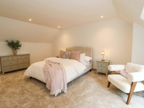 A bedroom with a bed, bedside tables, a chair, a lamp, and a plant. - Nevis Bridge House (Fort William)