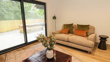 A living room with a sofa, a coffee table, and a view through a sliding glass door.