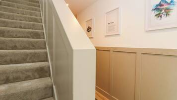 A staircase with carpeted steps leading to a landing.