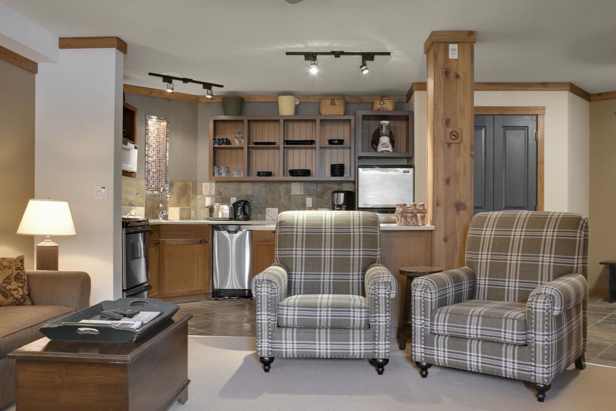 A modern kitchen with built-in appliances, a dining area with a table and chairs, and a living room with a sofa and a coffee table.