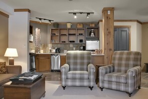 Una cocina moderna con electrodomésticos integrados, un comedor con mesa y sillas, y una sala de estar con sofá y mesa de centro.