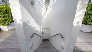 Una escalera con barandillas metálicas y una pared blanca.