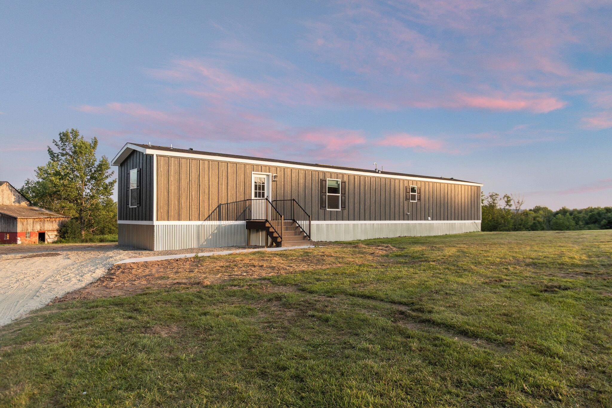 A single-story building with a metal exterior, a front porch, and a staircase leading to the entrance.