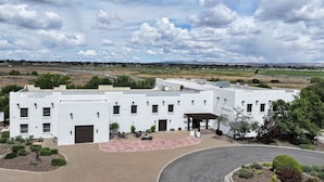 A white building with multiple windows and a covered patio area. - Inn at Gard Estate Wines (Prosser)