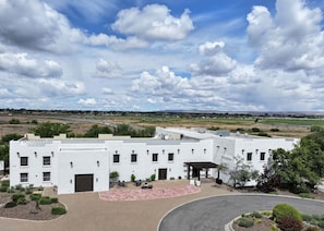 A white building with multiple windows and a covered patio area. - Inn at Gard Estate Wines (Prosser)