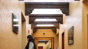 A narrow hallway with wooden flooring, a wooden bench with a mirror, and a door at the end. - Inn at Gard Estate Wines (Prosser)
