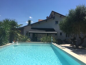 Ein klares Schwimmbecken mit einem Haus im Hintergrund.