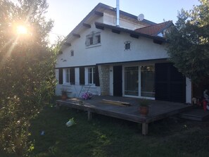 A two-story house with a balcony, a satellite dish, and a garage door. - Beautiful house nearby is operational (La Teste-de-Buch)