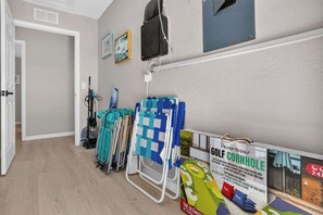 Ein Zimmer mit Tür, Staubsauger, Golfwagen und Schild für einen Golfplatz.