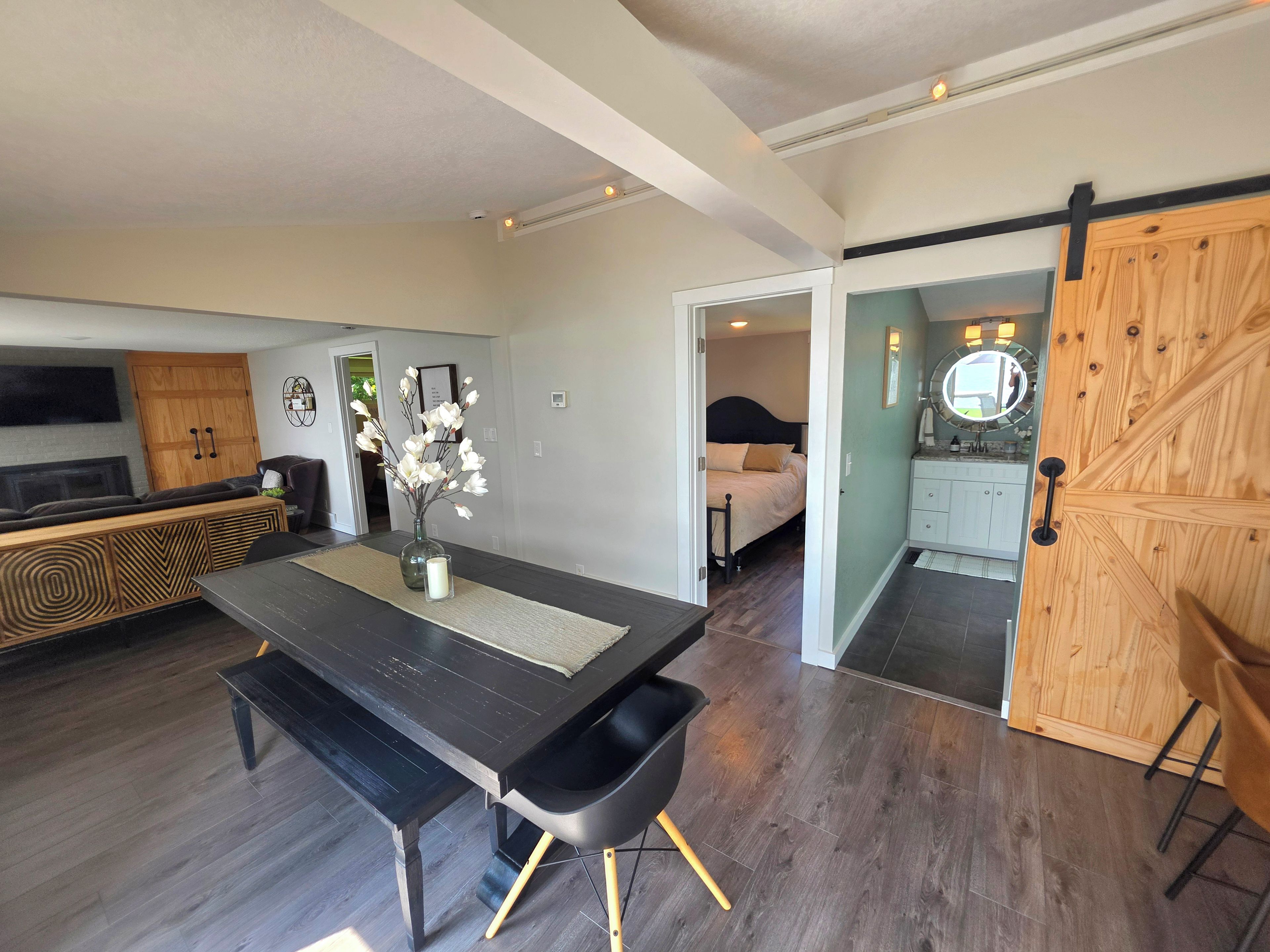 A modern interior with a dining area, a kitchen, and a bedroom.
