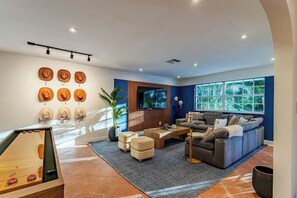 Ein modernes Wohnzimmer mit einer Couch, einem Couchtisch und einem an der Wand befestigten Fernseher.