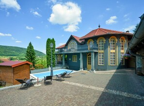 Ein Gebäude mit Pool, Außenbereich und Blick auf die Hügel.