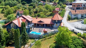 Una extensa propiedad con varias construcciones, piscina y un jardín bien cuidado.