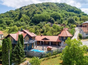 Un barrio residencial con casas, una piscina y montañas al fondo.