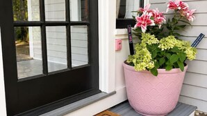 Une porte d’entrée avec un paillasson sur lequel on peut lire : « FERMEZ LA PORTE D’ENTRÉE ».