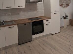 Eine moderne Küche mit Geschirrspüler, Backofen und einer Holzarbeitsplatte.
