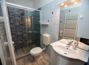 Ein modernes Badezimmer mit Duschkabine, Toilette und Waschbecken mit Spiegel.