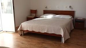 Una camera da letto con un letto di legno, un comodino, una sedia e un tavolino da notte.