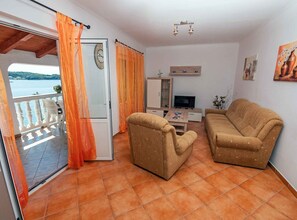 A living room with two sofas, a TV, and a small cabinet. - Superior Two Bedroom Apartment with Sea View and Terrace (Rab)