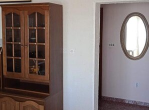 A room with a wooden cabinet and a round mirror on the wall. - Two Bedroom Apartment with Sea View and Terrace (Rogoznica)