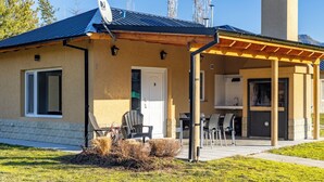 Un edificio a due piani con una veranda coperta, un'antenna parabolica e una porta con il numero 5.