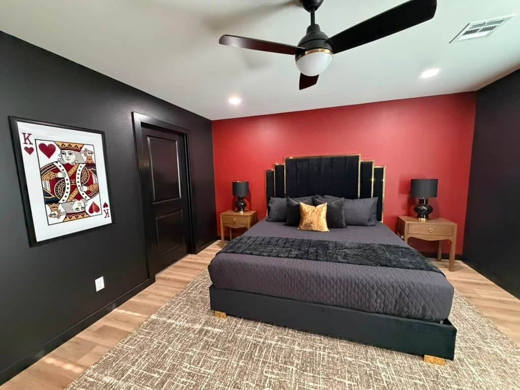Ein Schlafzimmer mit einem großen Bett, einem Deckenventilator, zwei Nachttischen mit Lampen und einem gerahmten Kunstwerk an der Wand.