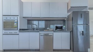 A modern kitchen with stainless steel appliances, including a dishwasher, oven, and refrigerator.
