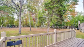 A wooden deck with a white railing, surrounded by trees with autumn foliage. - Pocono Mountains Gem (East Stroudsburg)