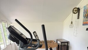Kotikuntosali, jossa on kuntopyörä, juoksumatto ja crosstrainer.